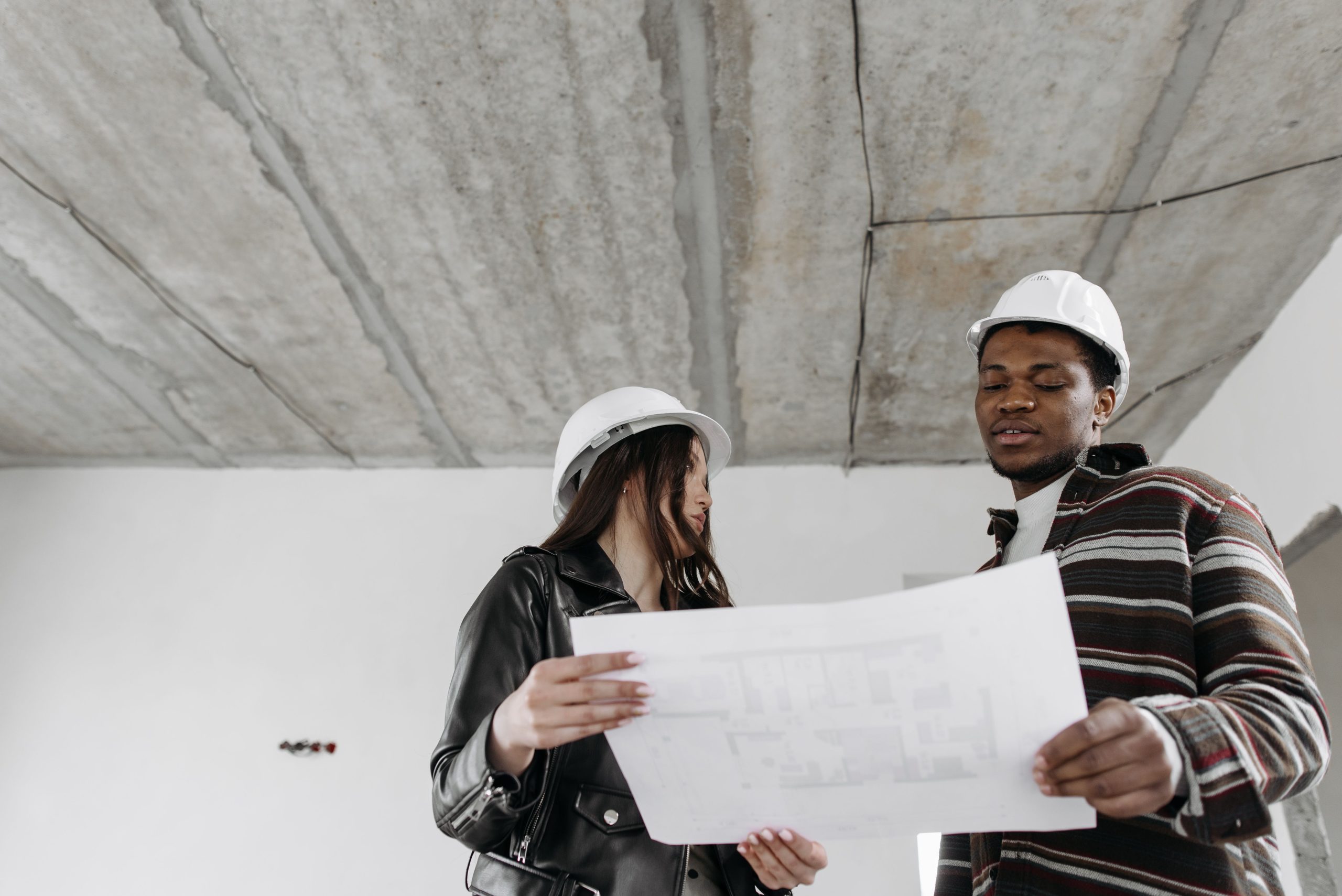 Deux architectes consultent blueprints immeuble inachevé