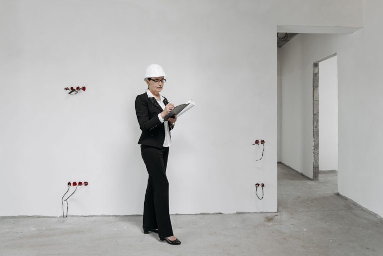 Femme avec casque vérifie des notes sur chantier