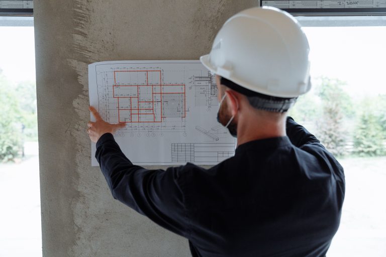 Ingénieur expert examine plans architecturaux chantier