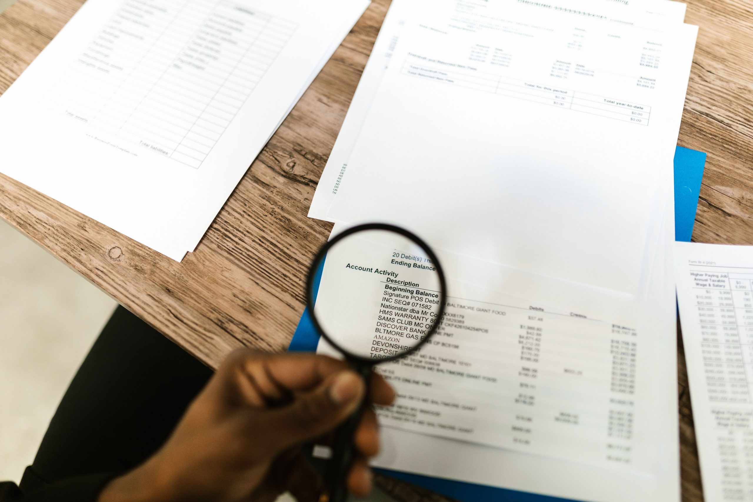 Loupe examinant documents financiers en détail