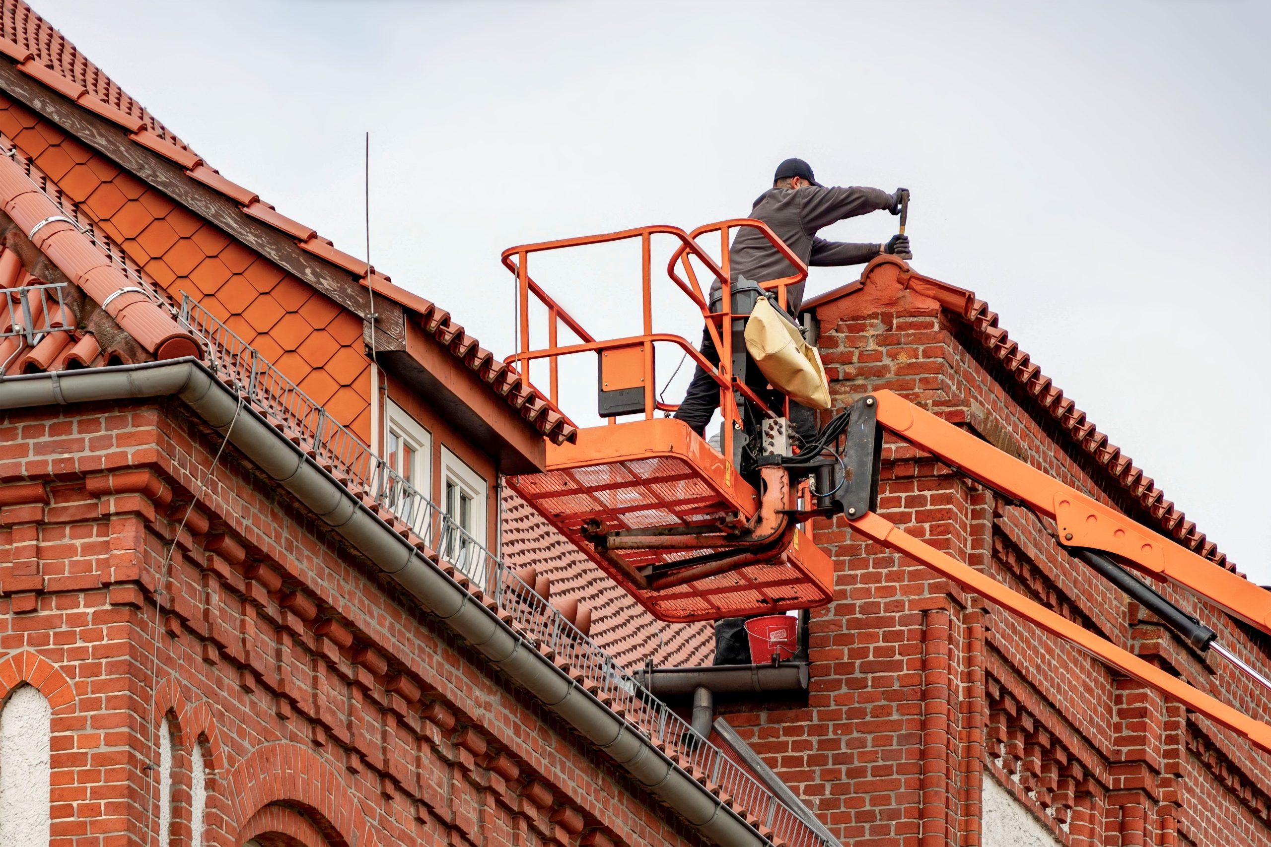 Couvreur inspectant toiture tiled brick building