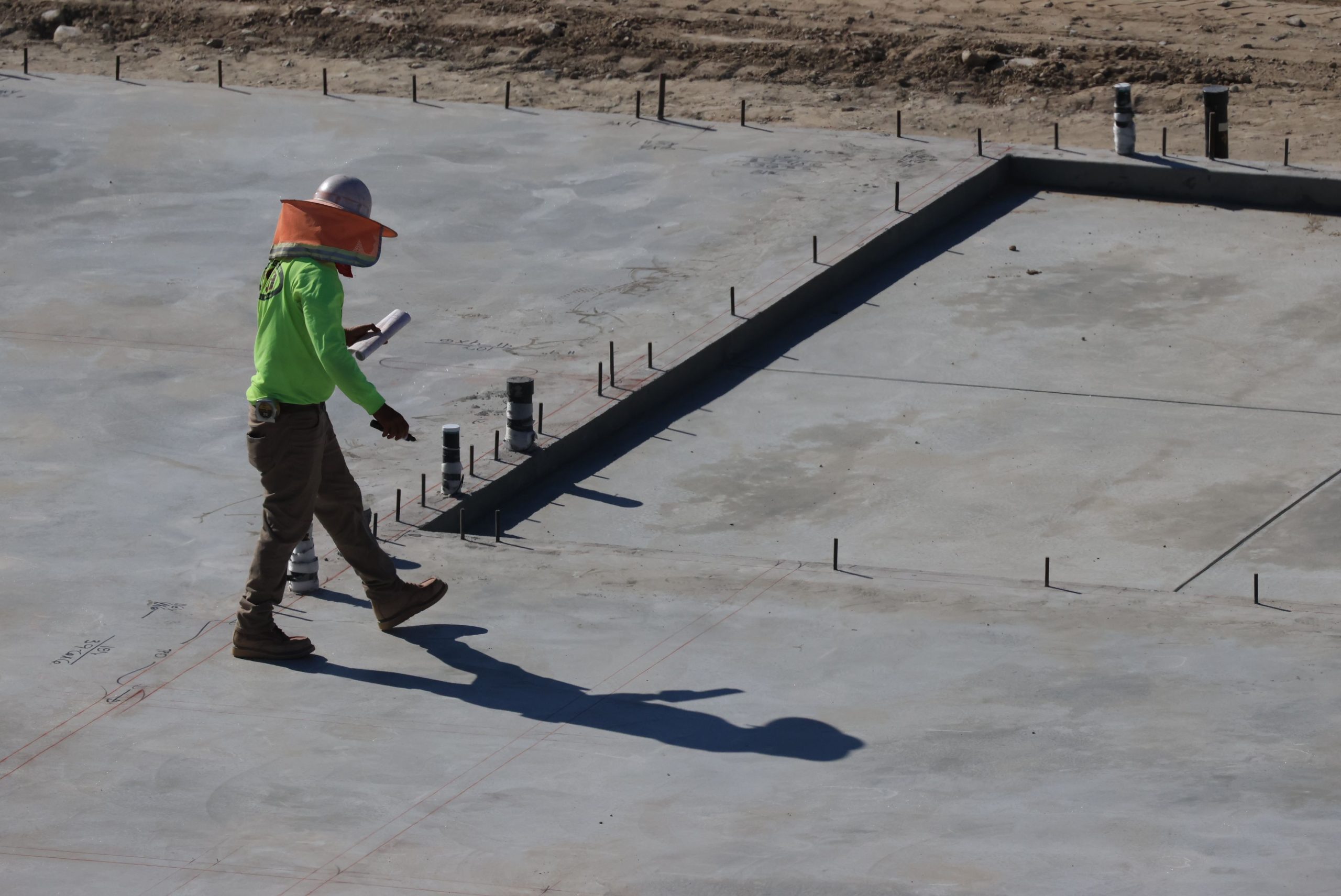 Expert examinant dalle béton chantier