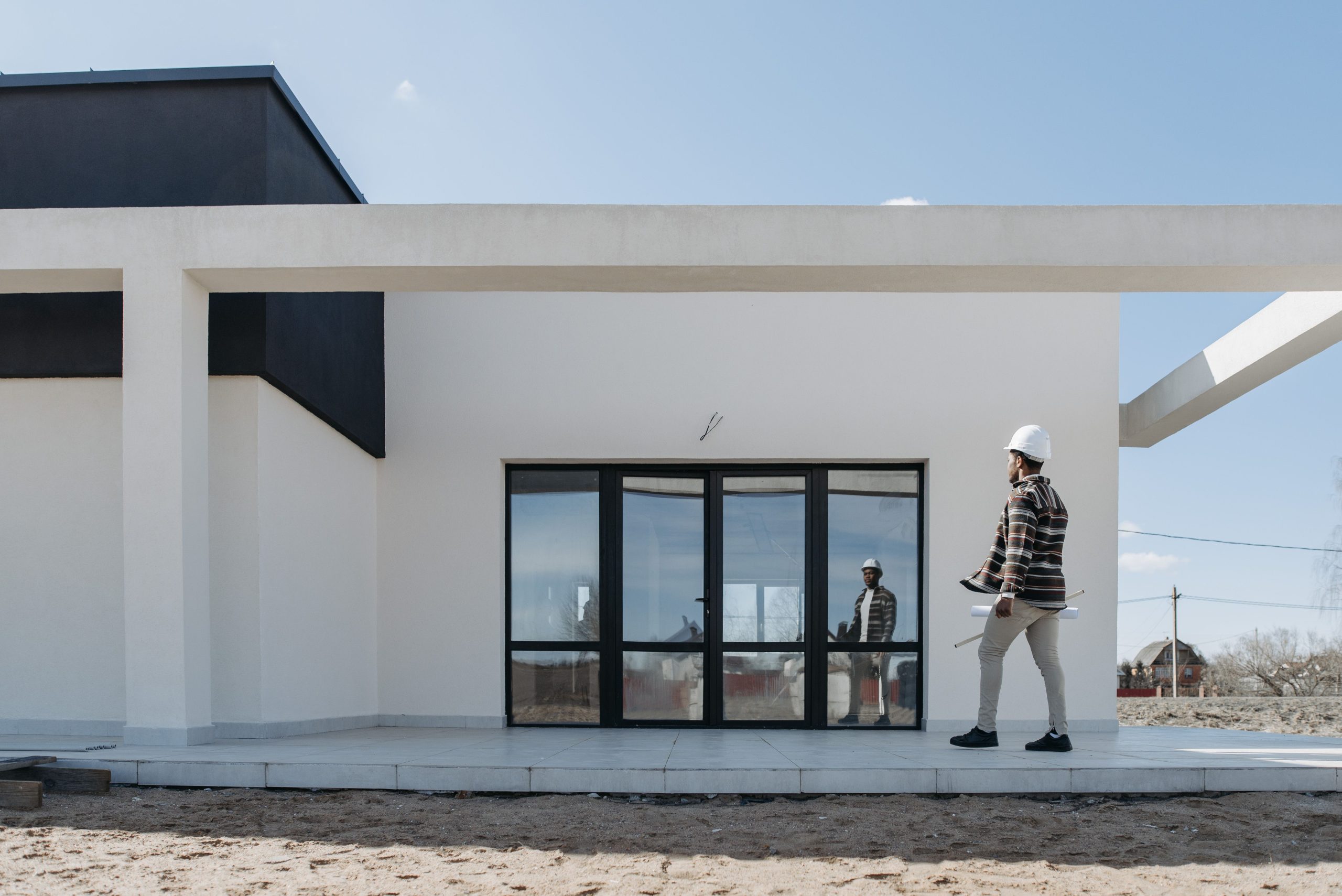 Architecte au casque inspectant façade maison moderne