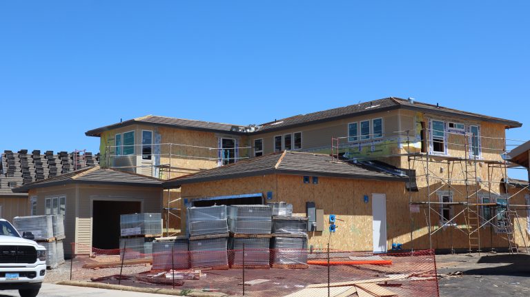 Maison moderne en construction avec échafaudages et matériaux