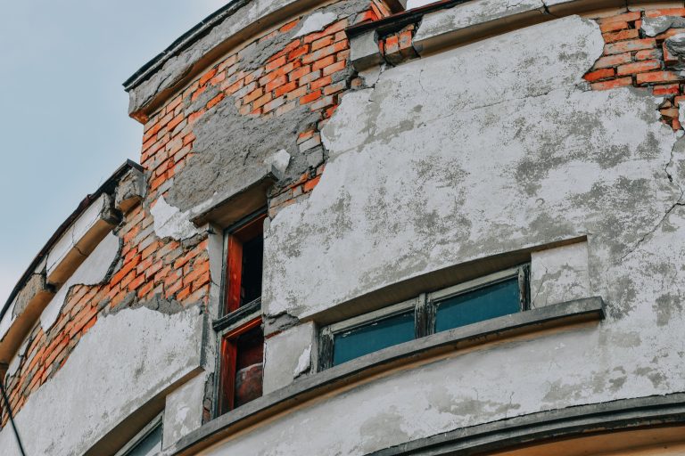 Facade de brique usée avec fissures et deterioration