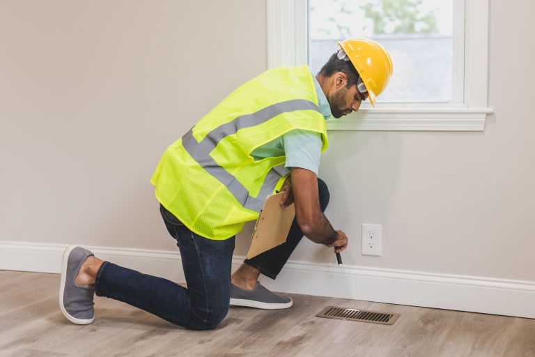 Ouvrier inspectant une maison avec outils