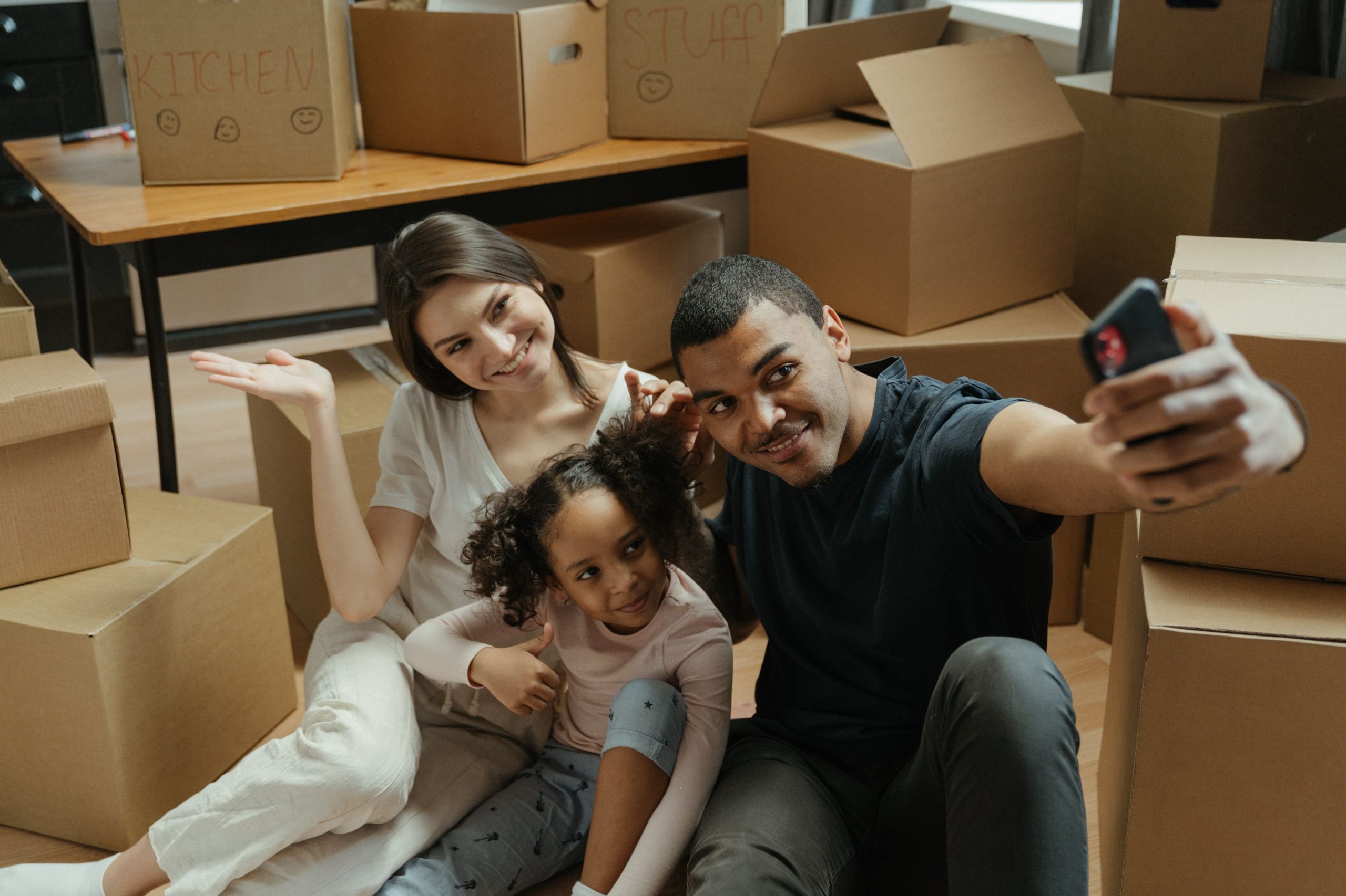 Famille joyeuse prenant un selfie parmi les cartons