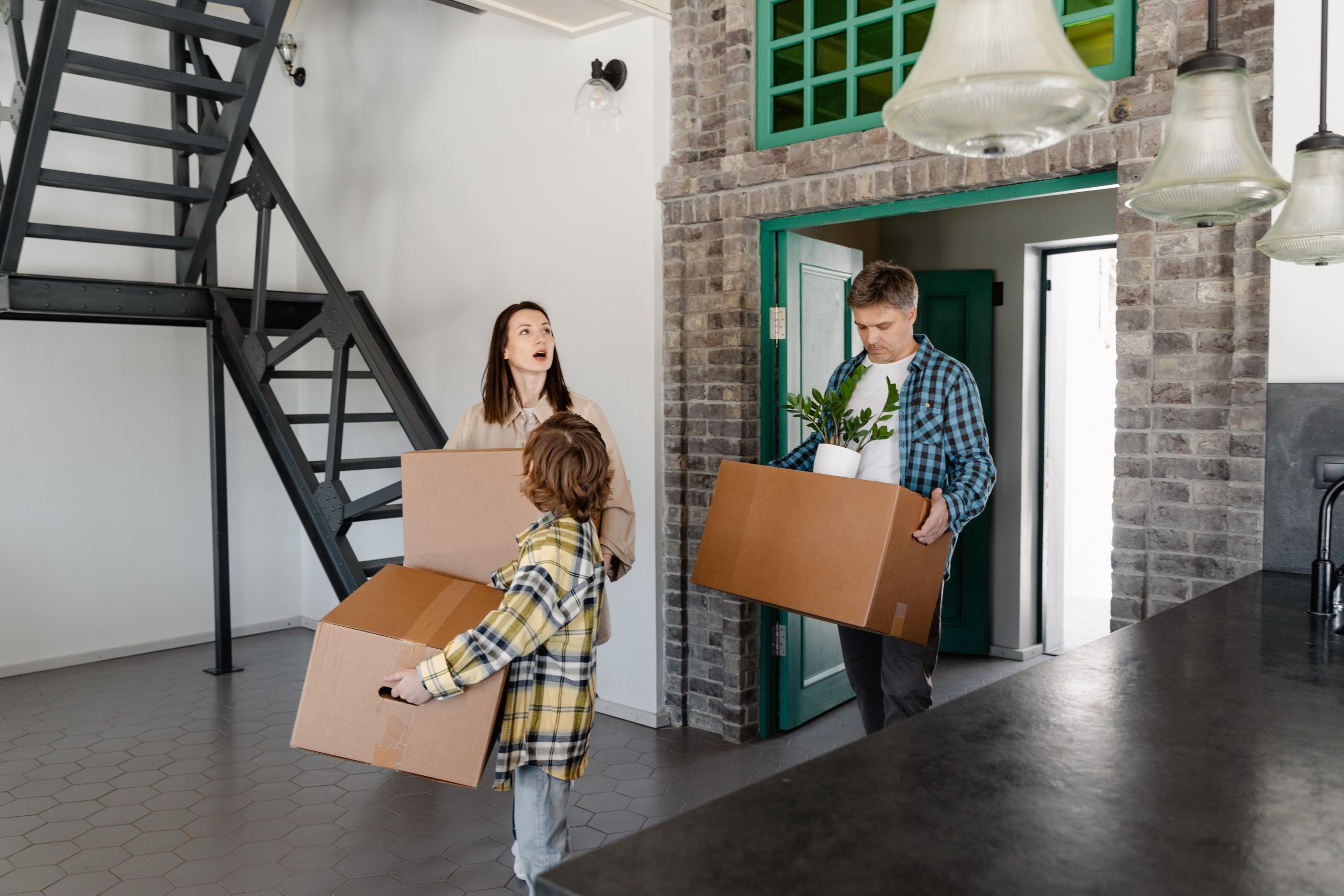Famille portant des cartons en déménageant dans un logement