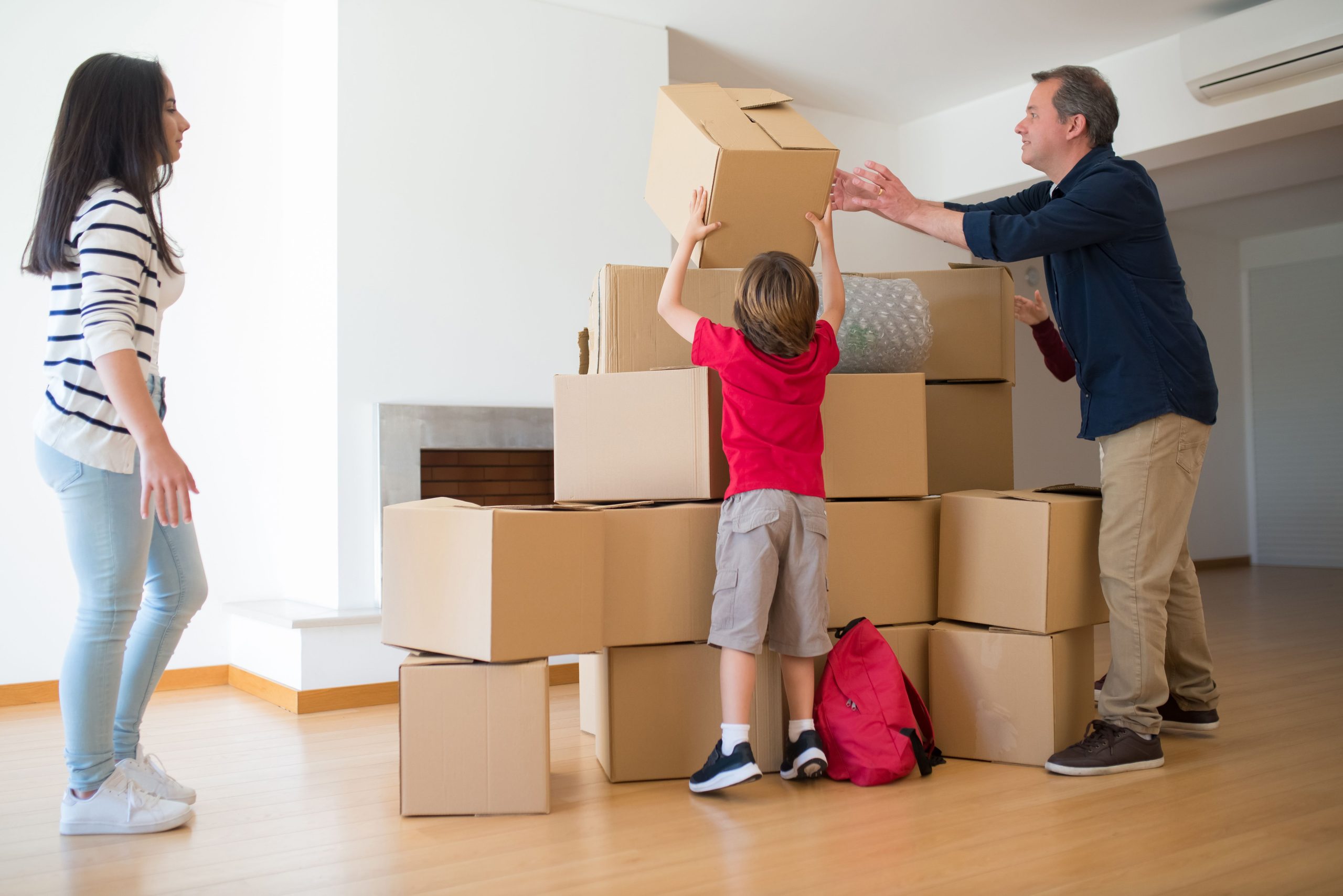 Famille déplaçant ensemble des cartons dans la maison
