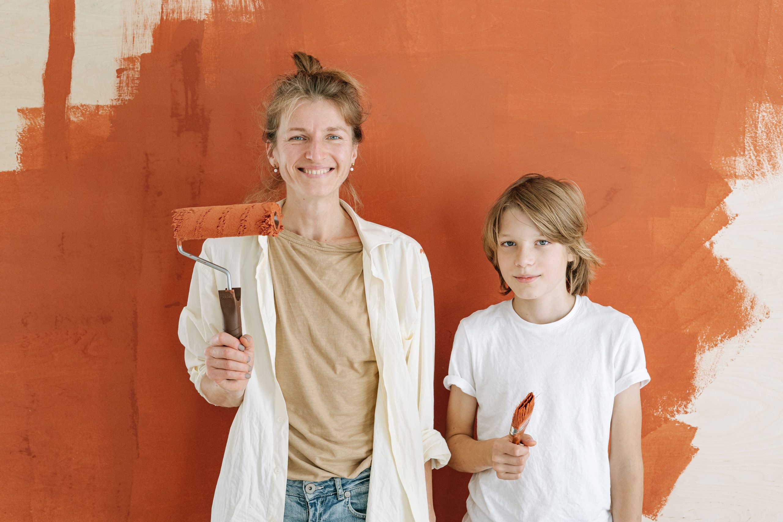Mère et fils souriants en train de peindre un mur